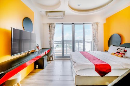 a bedroom with a large bed and a flat screen tv at Party of the Ocean B&B in Magong