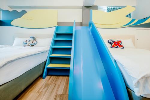 a bunk bed room with two beds and a staircase at Party of the Ocean B&B in Magong