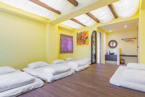 a row of beds in a room with yellow walls at Party of the Ocean B&B in Magong