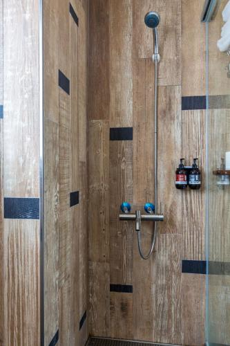 a shower in a bathroom with a wooden wall at Party of the Ocean B&B in Magong