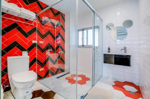 a bathroom with a toilet and a mosaic wall at Party of the Ocean B&B in Magong