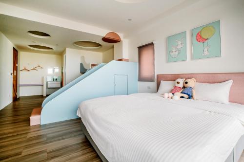 two teddy bears sitting on a bed in a bedroom at Party of the Ocean B&B in Magong
