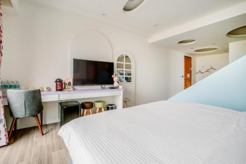 a bedroom with a white bed and a desk at Party of the Ocean B&B in Magong