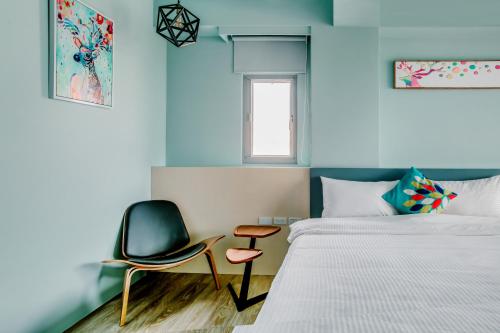 a bedroom with a chair next to a bed at Party of the Ocean B&B in Magong
