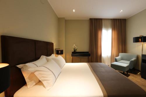 a hotel room with a large bed and a chair at LETO Boutique Hotel Zugdidi in Zugdidi