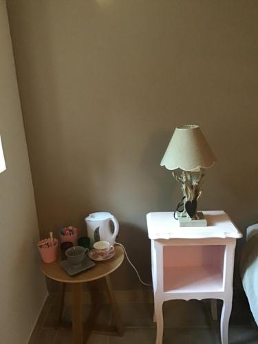 a table with a lamp on it next to a bed at Rêve d’Emma in Plan-dʼOrgon