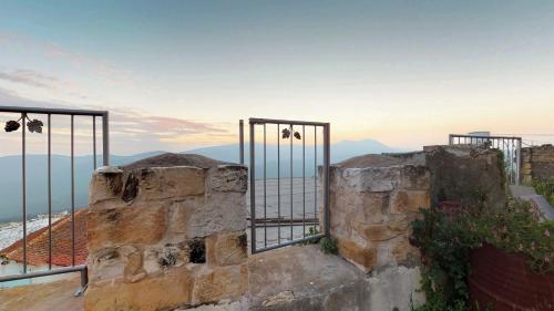 a gate on top of a stone wall with mountains in the background at HEMDAT NEFESH in Safed