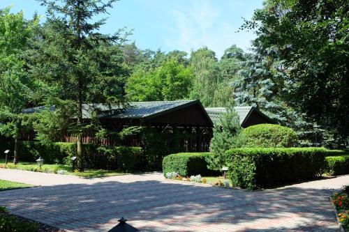 a house with a garden and a driveway at Leśny Ośrodek Szkoleniowy w Puszczykowie in Puszczykowo