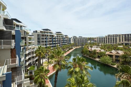 an aerial view of a river with palm trees and buildings at African Elite Waterfront in Cape Town