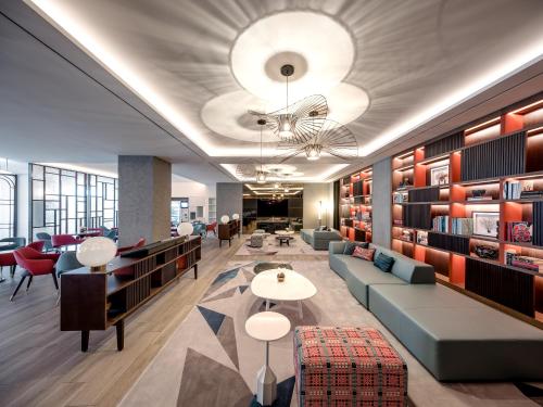 a lobby with a library with couches and tables at Art Paradiso, Paradise City in Incheon