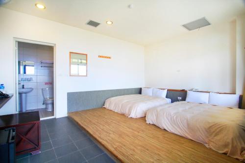 a large bed in a room with a bathroom at Sunnydale B&B in Ren'ai