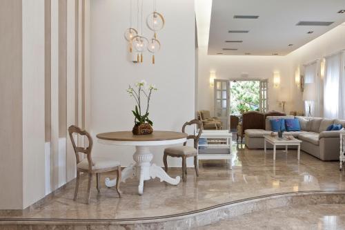 a living room with a table and chairs at Kamari Hotel in Platis Yialos Mykonos