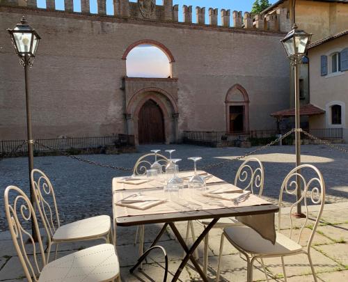 a table and chairs in a courtyard with a building at PALAZZO DE' ROSSI HOTEL in Sasso Marconi