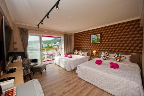 a hotel room with two beds and a balcony at 墾丁品喬旅店 in Eluan