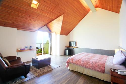 a bedroom with a bed and a chair in a room at Sunnydale B&B in Ren'ai