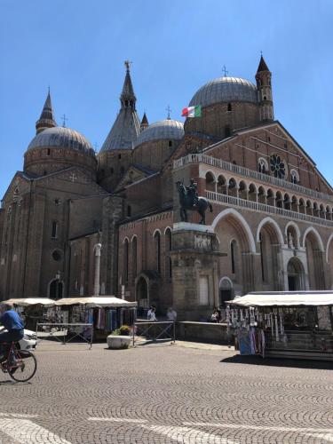 a large building with a person riding a bike in front at Padua Suite in Padova