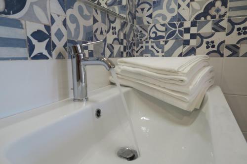 a bathroom sink with a faucet and towels on it at OASI DA VINCI in Tignale