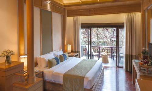 a bedroom with a large bed and a balcony at Chaweng Regent Beach Resort in Chaweng
