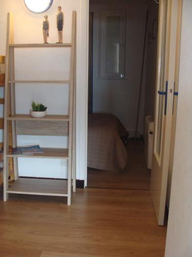 a room with a bed and a shelf with two figurines on it at la Bassure de Baas à Ambleteuse in Ambleteuse