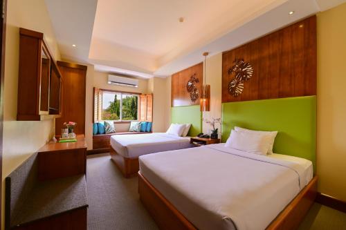 a hotel room with two beds and a couch at BE Resort Mactan in Mactan