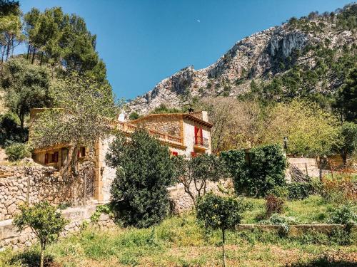 a stone house in front of a mountain at Finca Ses Fontanelles in Andratx