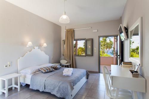 a bedroom with a bed and a table and a desk at Mythos Suites Diskos in Léntas