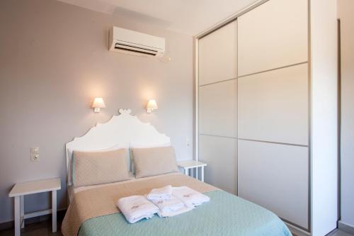 a bedroom with a bed with towels on it at Mythos Suites Diskos in Léntas