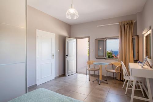 a living room with a table and chairs and a window at Mythos Suites Diskos in Léntas