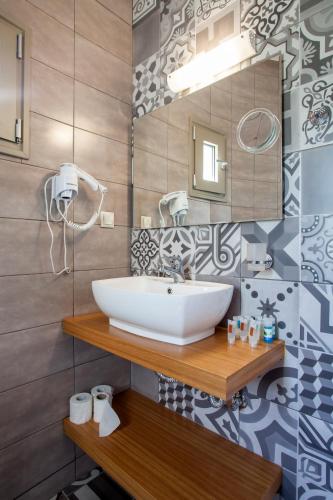 a bathroom with a sink and a mirror at Mythos Suites Diskos in Léntas