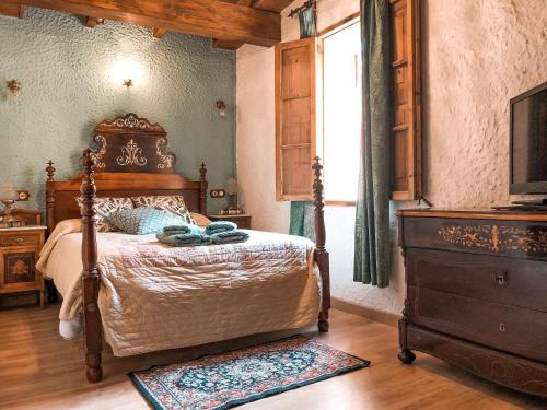 a bedroom with a bed and a television and a window at Finca Ses Fontanelles in Andratx