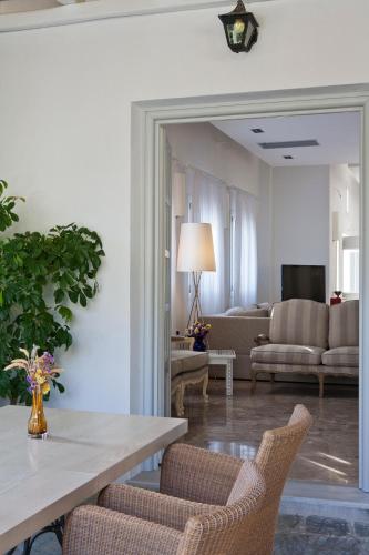 a living room with a table and chairs and a couch at Kamari Hotel in Platis Yialos Mykonos