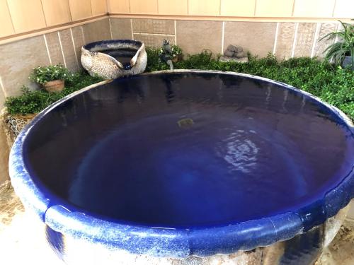 a large blue bath tub in a garden at Tabinoyado Saikawa in Kuroishi