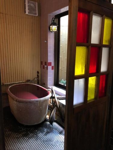 a bath tub in a bathroom with stained glass windows at Tabinoyado Saikawa in Kuroishi