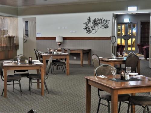 a dining room with wooden tables and chairs at Pittsworth Motor Inn in Pittsworth