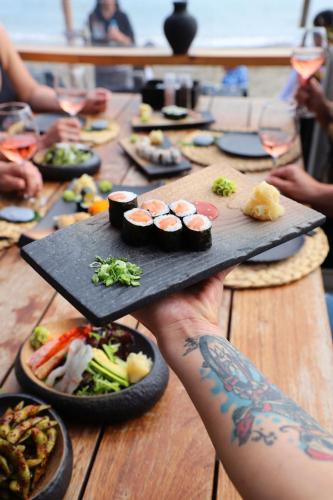 a person holding a plate of food on a table at Sun Hotel By En Vie Beach in Alanya