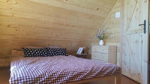 ein Schlafzimmer mit einem Bett und einer Holzwand in der Unterkunft Mazurskie Ranczo in Bogaczewo