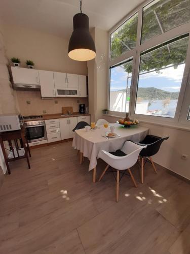 a kitchen and dining room with a table and chairs at Apartments La Mare in Primošten