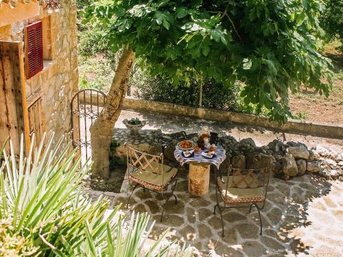 a table and chairs in a yard with a tree at Finca Ses Fontanelles in Andratx