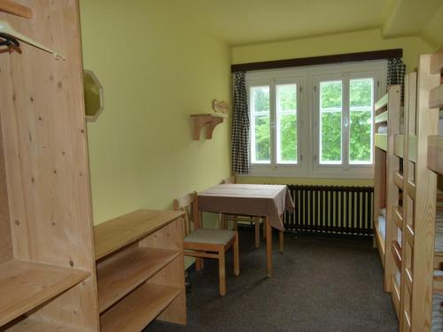 ペツ・ポト・スニェシュコウにあるChata Šohajkaのテーブルと窓が備わる小さな客室です。