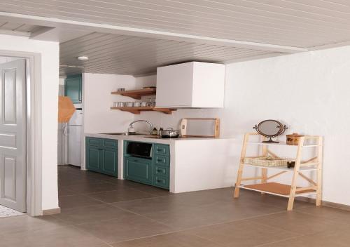 a kitchen with green cabinets and a table and a chair at Keresbino Hydra Port House in Hydra