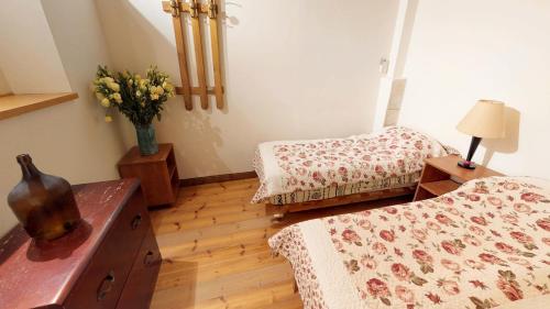 a bedroom with two beds and a vase of flowers at HEMDAT NEFESH in Safed