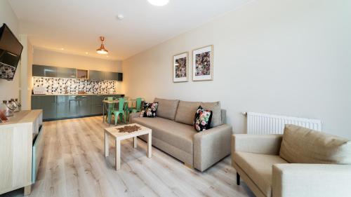 a living room with a couch and a table at Triventi Mountain Residence, Sun & Snow in Karpacz