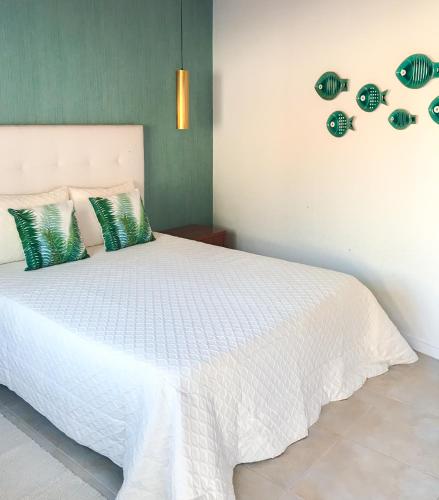 a bedroom with a white bed with green walls at NorthSpot in Nazaré
