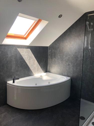 a bath tub in a bathroom with a skylight at 14 Millstone Court in Portstewart