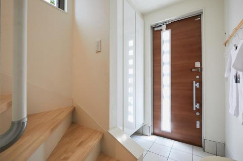um corredor com uma porta de madeira numa casa em P O IN T - 3BR Villa - Ikebukuro em Tóquio
