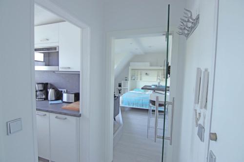 eine Küche und ein Wohnzimmer mit einem Bett in der Unterkunft Kuschelkajüte by WellenRausch in Travemünde
