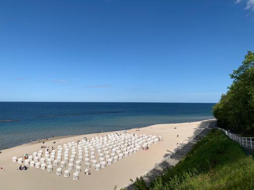a beach with many white umbrellas and people on it at Appartementanlage Lancken-Granitz in Lancken-Granitz