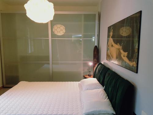 1 dormitorio con cama blanca y ventana en Casa Maya con giardino privato en Torre del Lago Puccini