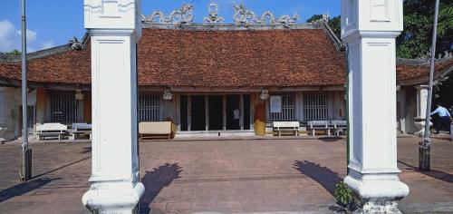 un grand bâtiment avec des colonnes blanches devant lui dans l'établissement Bảo An hotel Đảo Quan Lạn, à Làng Liễu