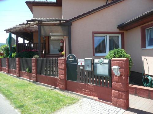 a house with a fence and two parking meters at Penzion U Tulaka in Dobřichovice